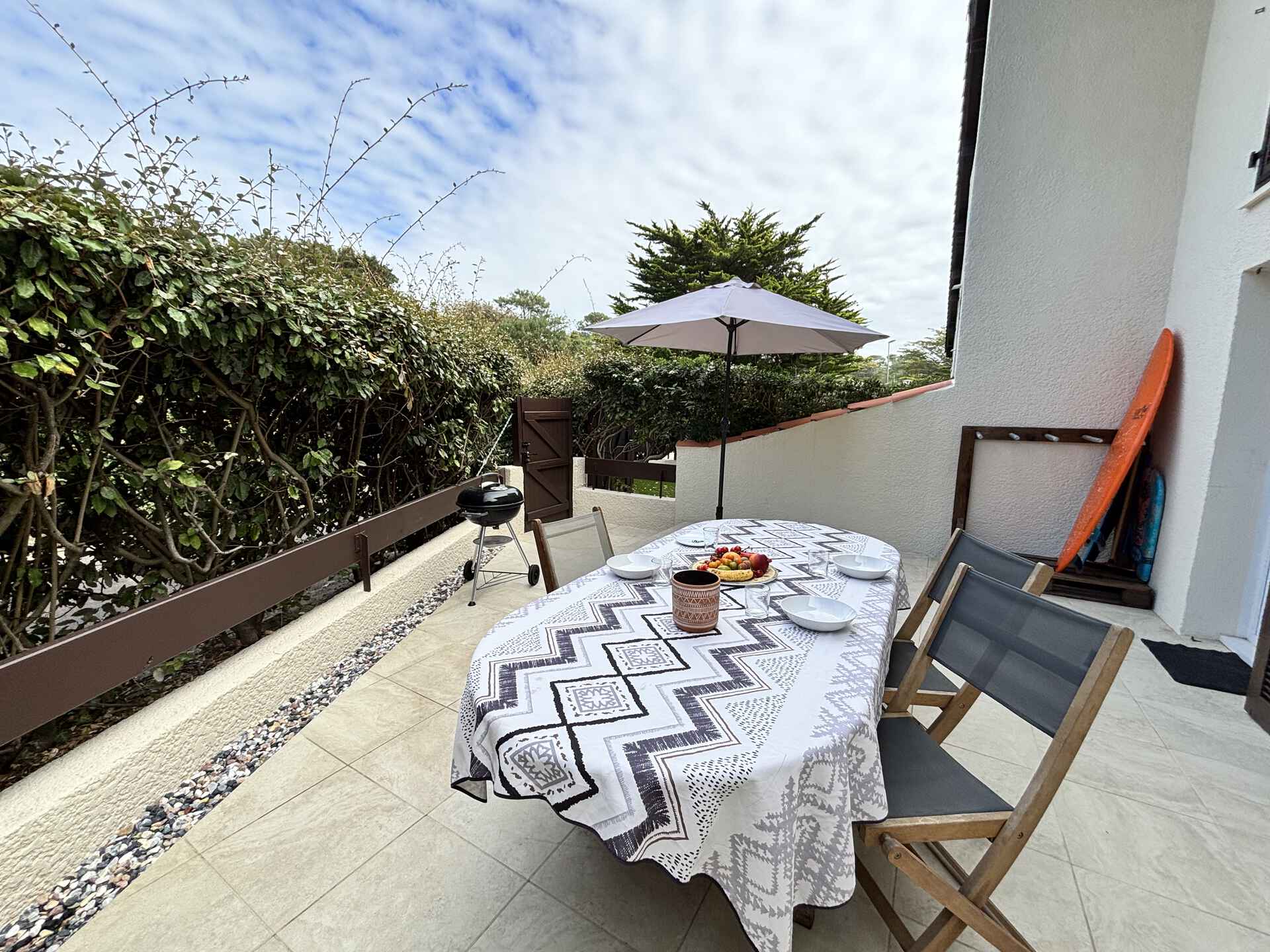 Sonnige Terrasse mit Surfbrettständer